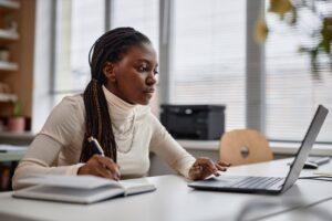 A woman doing research on her computer to determine if you can get pre-settlement funding without attorney consent.