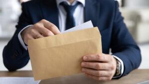 A man holding an envelope as a lawyer denies a client from getting a pre-settlement loan