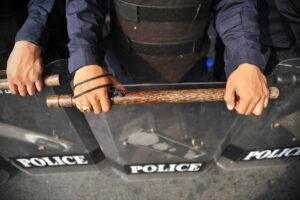 A group of police with their batons. You can learn more about the four most common examples of police brutality today.