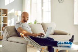 A man with a leg injury uses a computer to research Pegasus Legal Capital vs. Mustang Funding and find out which is right for him.