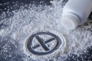 Talcum powder with cross sign on black background. How much is a talcum powder settlement worth?