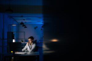 Businessman working on a computer in a dark office. How much is an unpaid wages settlement worth?