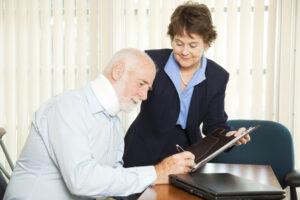 Person dealing with a neck injury and their personal injury lawyer, with the attorney handing this individual a document to sign so they can obtain a lawsuit settlement advance