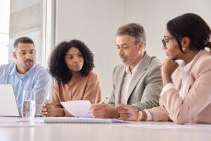 An attorney meets with a group of people to explain how much a class action lawsuit is worth.