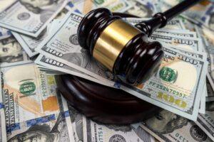 A gavel lying on a pile of cash. Learn about how much a nursing home abuse settlement is worth.