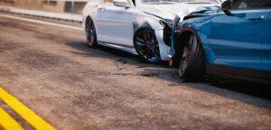 Two damaged cars on the road after a head-on collision. Learn about how much a rideshare accident settlement is worth.